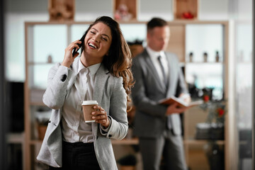 Businesswoman talking to the phone. Happy young woman working in office.	