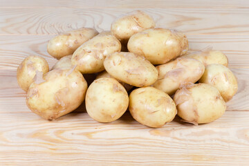 Fototapeta na wymiar Raw yellow young potatoes with skin on the rustic table