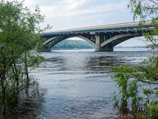 Arch concrete bridge across river in springtime, Kyiv, Ukraine