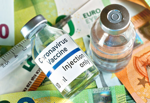 Coronavirus Covid-19 vaccine price / cost concept - glass vial with silver cap on pile of euro bank notes, hypodermic syringe near, closeup detail (own sticker design, dummy data - not real product)
