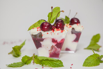 Beautiful dessert with cherries, whipped cream and mint
