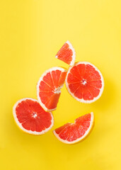 Orange slices in the air on yellow background.
