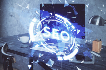Multi exposure of table with computer and seo drawing hologram. Search optimization concept.