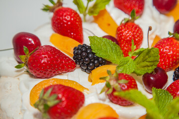 Beautiful dessert with berries: cherries, strawberries, blackberries, peaches and mint