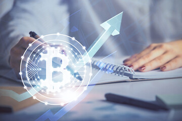 Cryptocurrency hologram over woman's hands writing background. Concept of blockchain. Double...