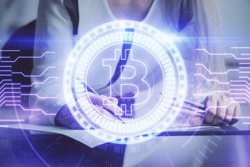 Cryptocurrency hologram over woman's hands writing background. Concept of blockchain. Double...