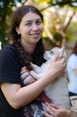 Photo of a girl and a husky puppy in her arms