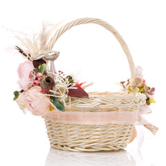 Fototapeta na wymiar Easter basket on white background. Decorated with pink flowers and a small decorative ceramic hare. Ribbons and lace.