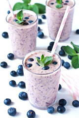 Fresh blueberry smoothie with mint leaves  and berries on wooden table