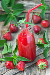 Delicious strawberry smoothie with mint leaves  and fresh berries in glass jar
