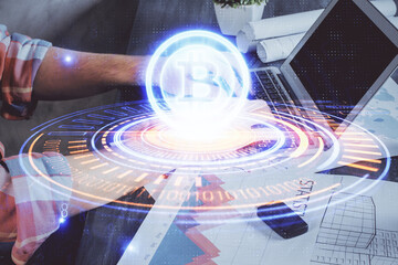 Crypto currency theme hologram with businessman working on computer on background. Concept of...