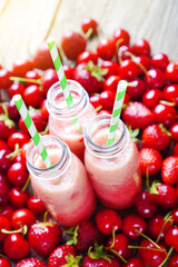 Summer vitamin smoothie cocktails on a red berries background