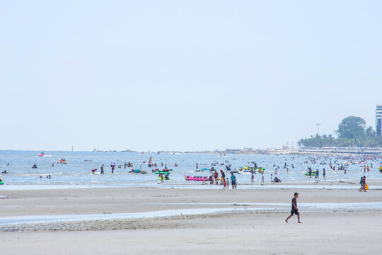 Many tourists walk on the beach  Background sea and large buildings at Bangsaen Beach, Chonburi in Thailand. June 21 , 2020 - Powered by Adobe