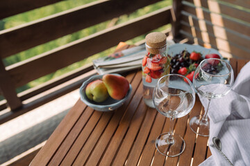 Summer healthy lemonade made of still water, berries, lemon and mint leaves. Picnic on terrace.