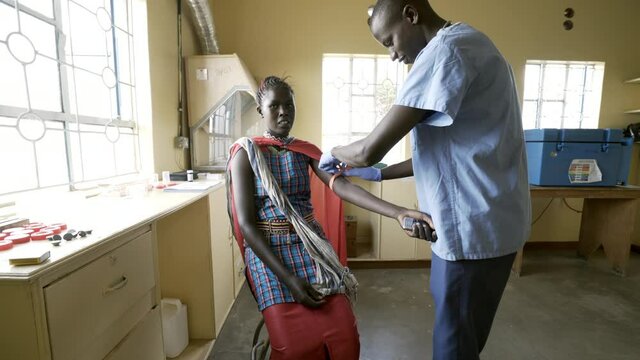 Doctors working with mothers and babies in busy neonatal clinic. Africa