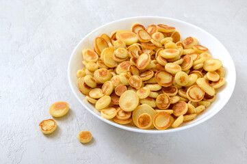 Pancake cereal in a bowl on a light background. Tasty and trendy breakfast. Organic Dutch Mini-Pancakes. Foods trend.