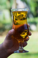 A glass of beer and a male hand.