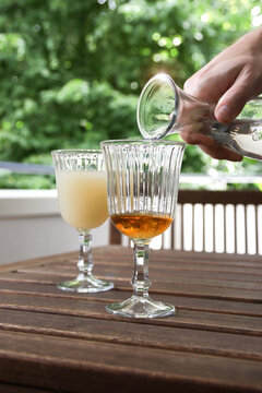 mann f&uuml;llt pastis gl&auml;ser mit wasser aus der karaffe auf