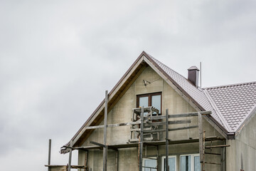 The process of building a private house cottage, scaffolding around the house of stone and concrete