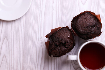 delicious brown chocolate muffin cakes on the white rustic wooden surface. close up. minimalism style