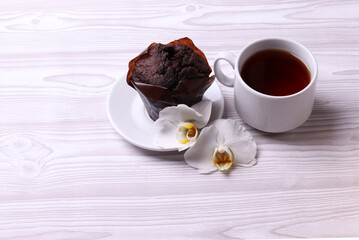 delicious brown chocolate muffin cakes on the white rustic wooden surface. close up. minimalism style