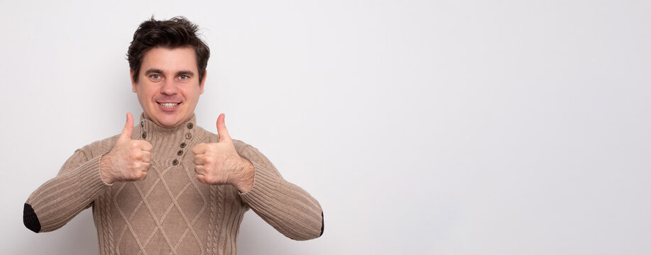 Handsome man showing thumbs up sign. Smiling positive man. Banner with blank space for text.