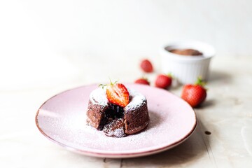 Chocolate fondants with powdered sugar and strawberries 