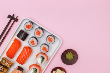 Sushi set with salmon on pink background, top view.