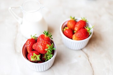 Strawberries in white ramekins in the company of milk