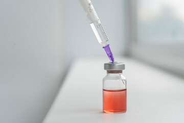 Drug development process, a doctor in a protective suit holds an ampoule