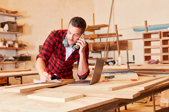 Craftsman in the carpentry on the phone