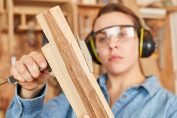 Woman as a carpenter apprentice with vernier caliper