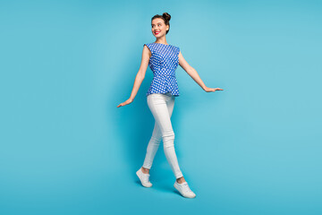 Full body profile photo of pretty funny lady good mood walk down street summer warm sunny day wear dotted retro blouse white pants shoes isolated blue color background