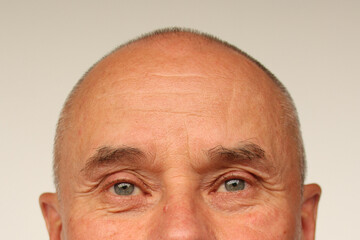 old male eyes and wrinkled forehead, part of the face close-up, overhang, the concept of age-related changes in human skin