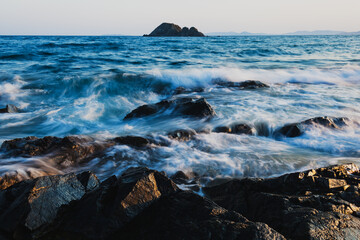 Obraz premium Rocks on the beach, long exposure to the sea and rocks, waves hitting the rocks.