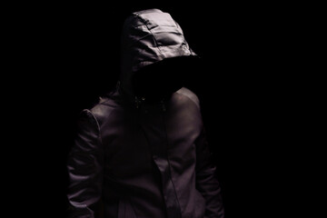 Naklejka na ściany i meble Portrait of Invisible man in the hood on black background.