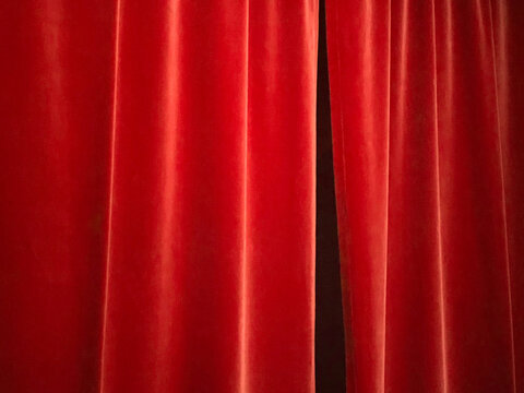 Red velvet drapes with a black gap.