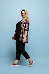 Confident, stylish. Young woman in casual wear on blue background. Bodypositive character, feminism, loving herself, beauty concept. Plus size businesswoman, beautiful girl. Inclusion, diversity.