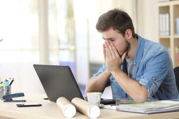 Worried entrepreneur looking at laptop at office