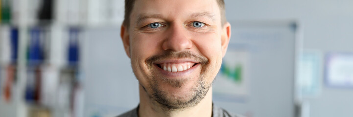 Unshaven man in t-shirt stands at home and smiles. Sit at home and relax. Take breath before new work week. Properly organize self-isolation. Basic hygiene during pandemic. Time COVID-19