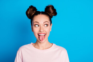 Closeup photo of attractive childish lady two funny buns stick tongue out mouth teasing boyfriend avoid look eyes bad behavior wear casual pink t-shirt isolated bright blue color background