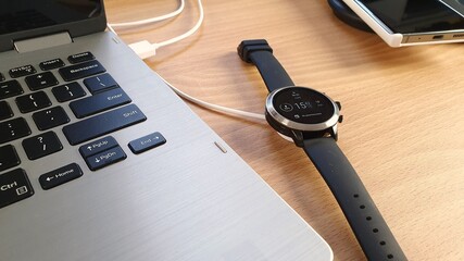 Mobile phone and smart watch on a dual wireless charger with a tablet and a stylus concept for...