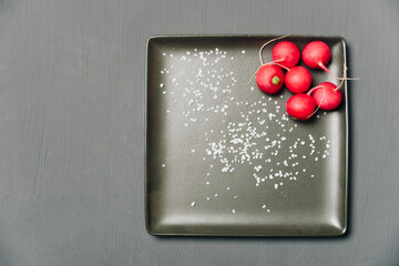 red radish on a plate on a dark background