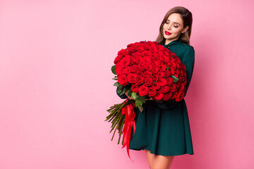 Photo of attractive charming lady hold large red roses bouquet enjoy pleasant smell cardiac feelings wear green mini dress isolated pastel pink color background
