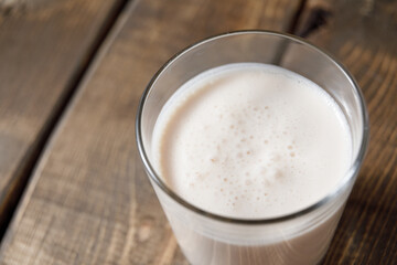 Probiotic cold fermented dairy drink kefir on wooden background.