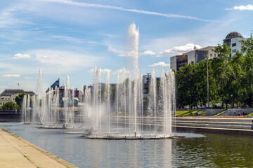 Fototapeta premium Several fountains in a city leisure park in the middle of a metropolis
