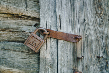 Old rusty lock on an old wooden door