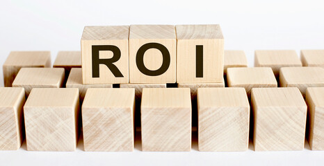 ROI word from wooden blocks on desk, search engine optimization concept