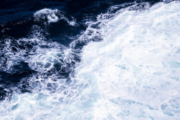 Naklejka na ściany i meble Deep blue sea water with splash and foam. Aerial view to sea waves. Blue water background