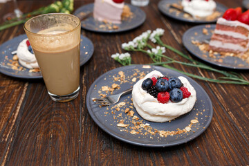 Sweet cakes with summer berries on a wooden table. Party, sweet table. Summer offer desserts in the restaurant.